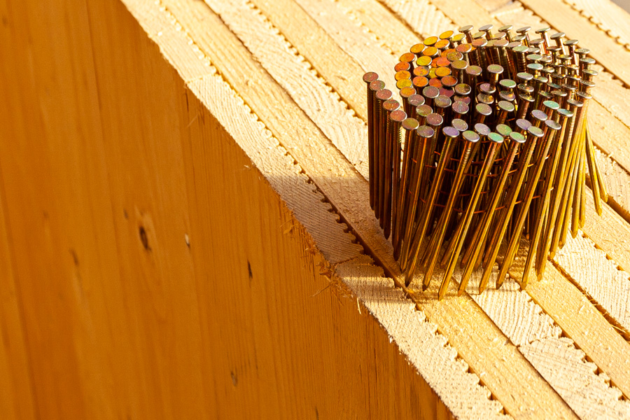 Baustelle, Nägel auf Massivholzwand